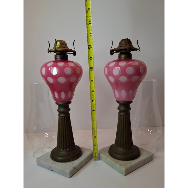 This offering features a rare and beautiful pair of mid-19th-century glass lamp fonts, likely American (Boston & Sandwich...