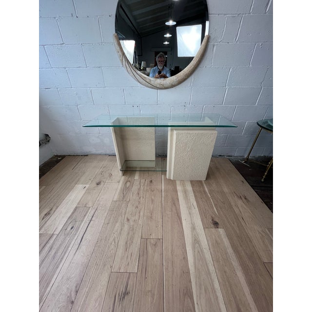 Finished in textured ivory or off-white. Two substantial geometric supports create a striking profile, while a clear glass...