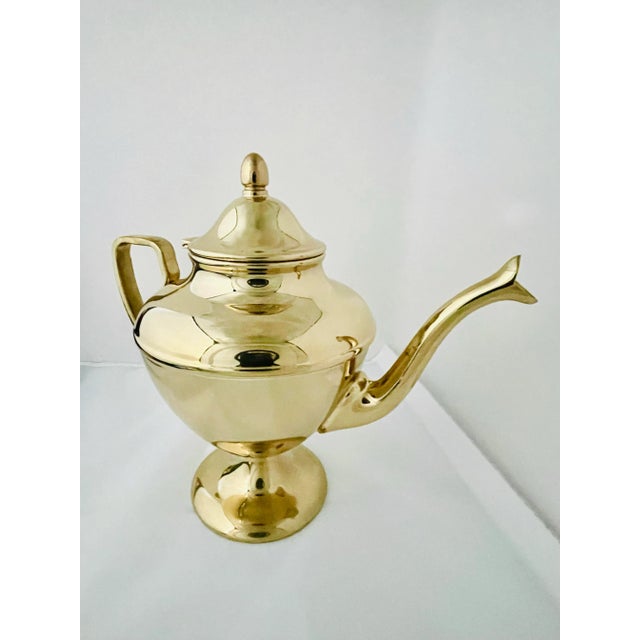 A beautiful gold tinted bronze alloy tea pot in the Hollywood Regency style.