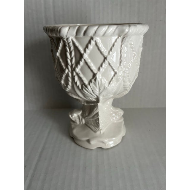 A single white ceramic cachepot or footed vase featuring nautical rope style relief decoration with a sea serpent base.