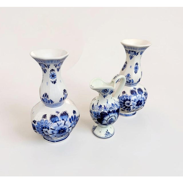 A highly decorative set of three antique Dutch Delft Blue Delftware vases, comprising a matching pair of traditional...