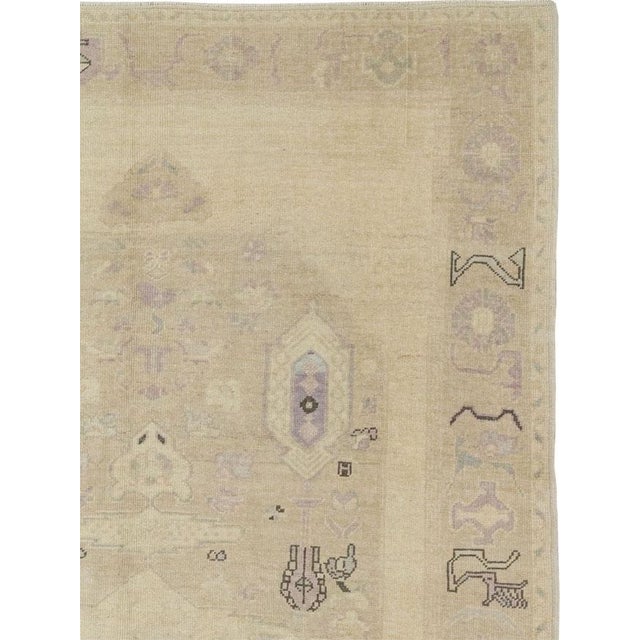 This mid-20th-century Turkish Anatolian accent rug presents a softly layered geometric composition across a pale ivory,...