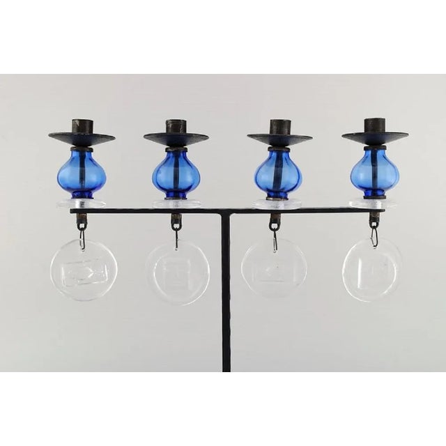 Erik Höglund for Kosta Boda, large candle holder in cast iron with mouth blown glass. Mid 20th century. In excellent...