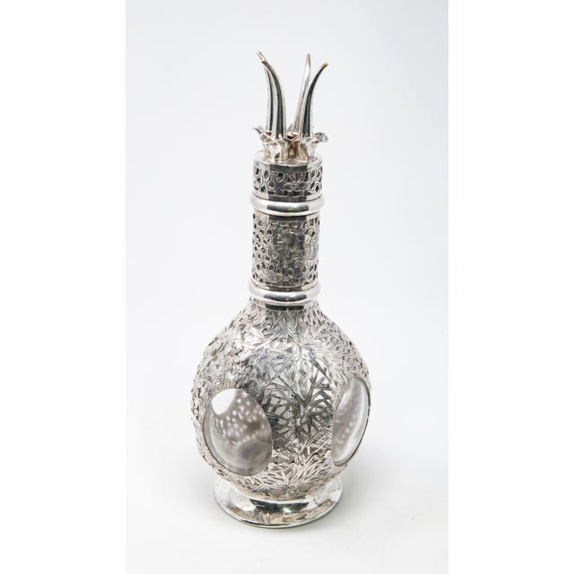 Silver over glass decanter from the late 1800. Beautiful sterling with a floral motif surrounds a decanter that is divided...