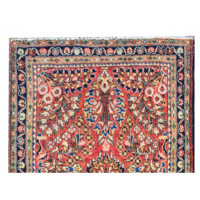 A wonderful early 20th century petite Persian Sarouk rug with a large-scale mirrored floral pattern woven in light and...