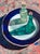 Secret Meeting by Tracy Wall | Oil on canvas Still life of two green bottles on a plate For Sale
