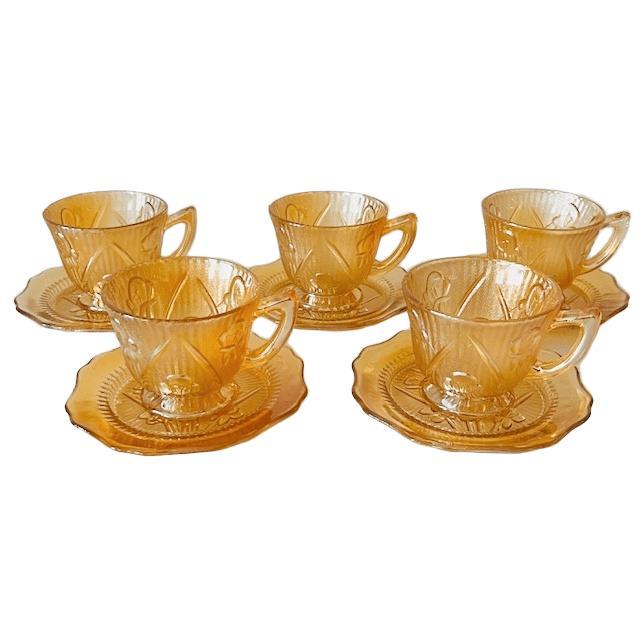A beautiful set of five vintage Jeanette Carnival glass cups and saucers with Iris & Herringbone pattern made of peach-...