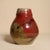 A beautifully hand-thrown studio pottery vase featuring a rich, reactive glaze in deep oxblood red, blending into earthy...