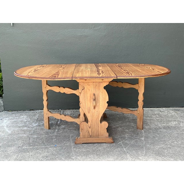 This vintage drop leaf dining table is a masterclass in rustic functionality and Early American charm. Hand-crafted from...