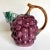 Here is a charming pitcher that resembles a bundle of purple grapes with a brown, stem handle and leafy spout! It is...