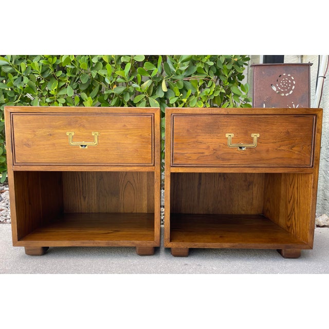 Pair of Henredon Artifacts campaign style nightstands featuring brass hardware and dovetail drawer construction. Clean...