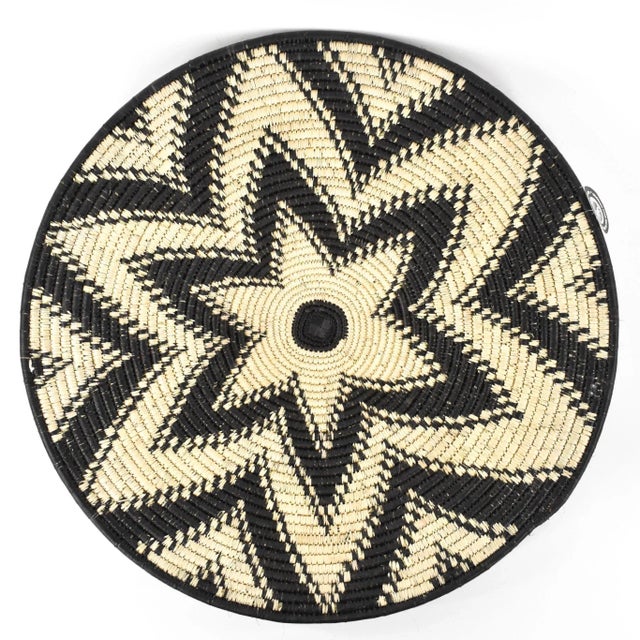 This saucer-shaped bowl, called an imbenge, is traditionally woven with Ilala palm and grass fibers. A modern version is...