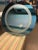 Round decorative wall mirror with a blueish tint.