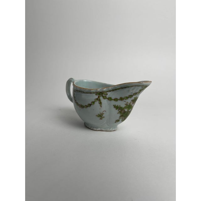 This Chinese export porcelain sauce boat, decorated with green floral motifs, is a fine example of the elegant and highly...