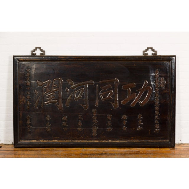 A Chinese Antique Shop Sign with Carved Calligraphy from the 19th century with dark brown/black lacquer, calligraphy...