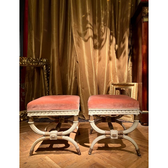 This pair of 19th century Italian Louis XVI style lacquered and parcel gilt stools, designed with exceptional attention to...