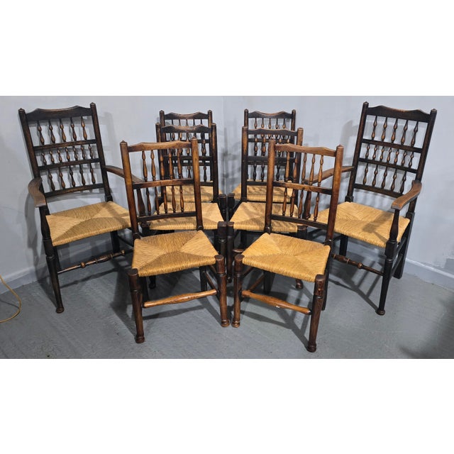 A super set of eight harlequin country elm kitchen dining chairs, including two carvers, rush seats in very good condition\.