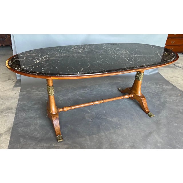 Exceptional Art Deco period dining or center table. Walnut with bronze-tipped feet and decorative appliqués with original...