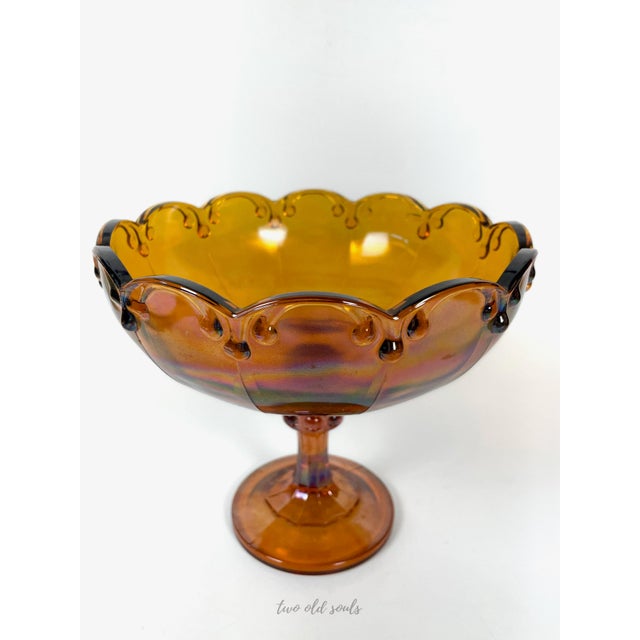 Beautiful vintage amber carnival glass pedestal bowl. This piece features a scalloped with tear drop accents along the...