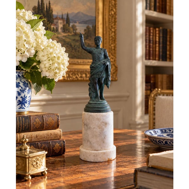 A classic Grand Tour style figure rendered in brass with a verdigris-toned finish, mounted on a substantial marble base....
