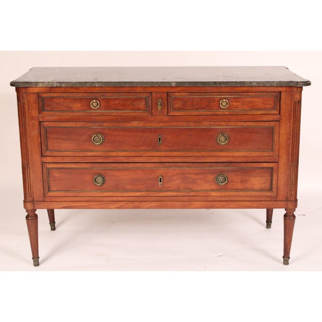 Antique Louis XVI style brass mounted mahogany chest of drawers, late 19th century. With a rectangular gray marble top...