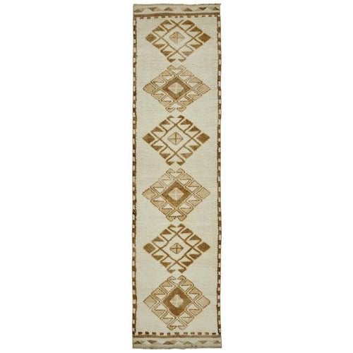 This exquisite runner rug is a rare example of tribal craftsmanship, hand-knotted by the women of the Herki tribe during...
