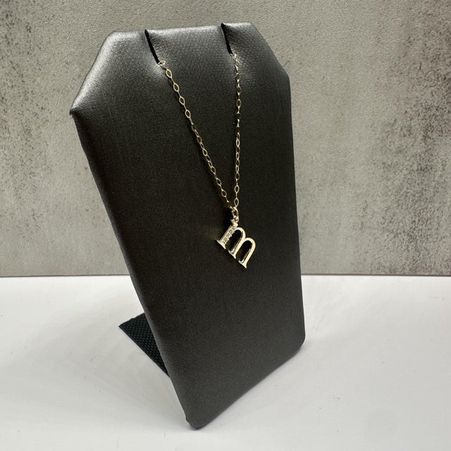 This elegant diamond “M” initial necklace in 14kt yellow gold features 0.02 carats total weight of natural GH VS/SI round...