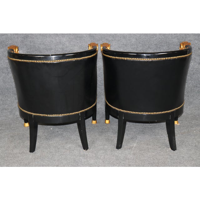 This striking pair of French Directoire or Regency-style armchairs combines a dramatic ebonized finish with classical gilt...