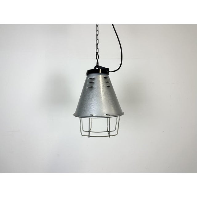Industrial factory hanging lamp made by Polam Wilkasy in Poland during the 1970s. It features a grey hammerpaint aluminium...