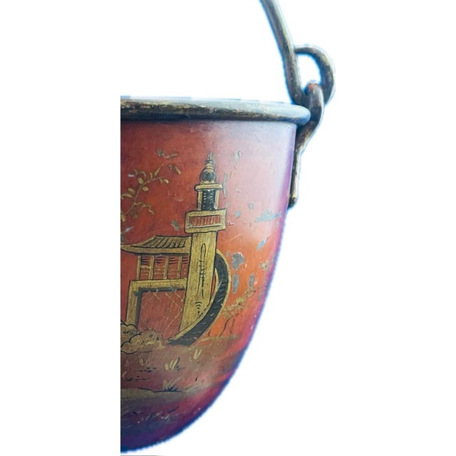 An antique Chinese lacquered metal bucket painted with a heavy iron swing handle attached at the rim, gilt and polychrome...
