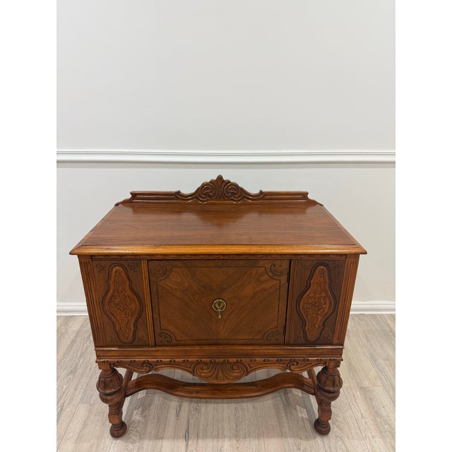 Antique Jacobean Revival Style Sideboard Buffet Credenza. Features intricate decorative carvings on the doors and a carved...
