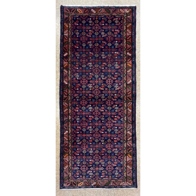 Hand-knotted runner from the Hamadan region of western Iran, featuring an allover geometric lattice pattern set within a...
