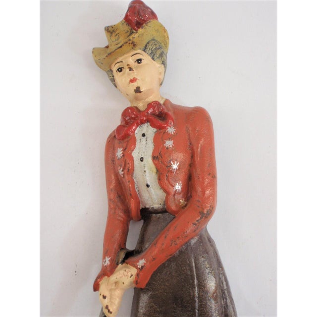 Lady golfer cast metal doorstop in vintage attire. Brightly colored all over hand painting with chip wear to the finish....