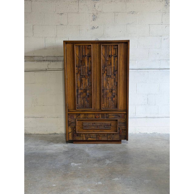 This striking armoire dresser features the iconic, heavily textured Brutalist relief pattern. Behind its double doors,...