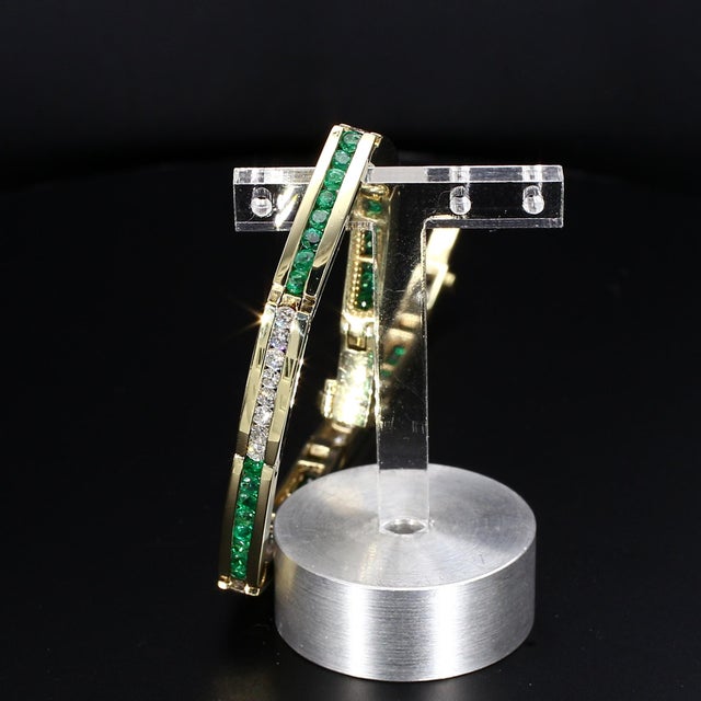 Here is a 14k Yellow Gold Tennis Bracelet featuring Brilliant White Diamonds and Emeralds, each weighing 0.04 carats. The...