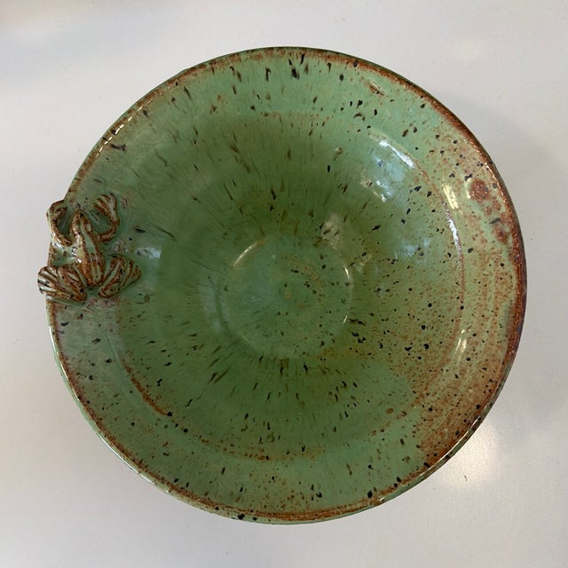 Handmade studio pottery bowl featuring a rich green glaze with natural speckling and an applied sculptural detail along...