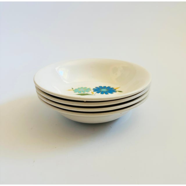 A set of 4 mid century ceramic small bowls by American Ironstone. Glossy white glaze with a pattern of blue flowers on...