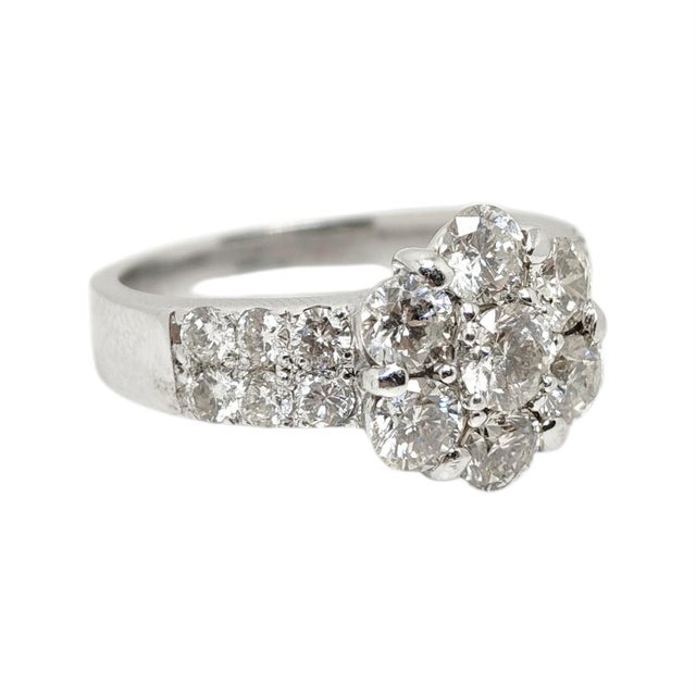 Vintage 18k white gold ring featuring a sleek, contemporary design. The front features a flower cluster design composed of...