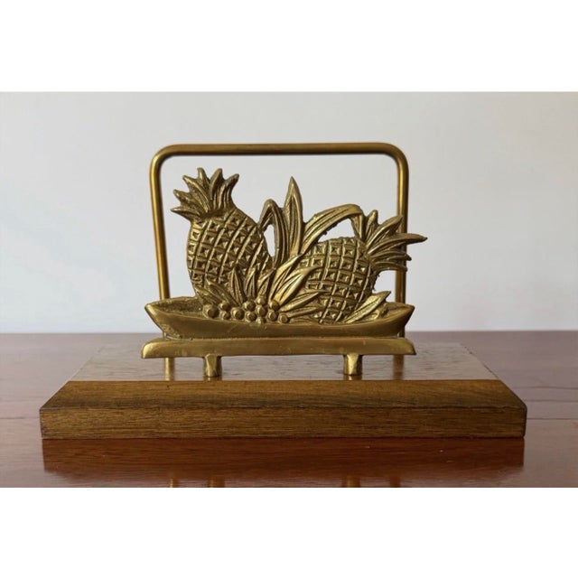 Charming vintage pineapple napkin holder featuring a sculptural brass pineapple mounted on a warm-toned wood base. The...