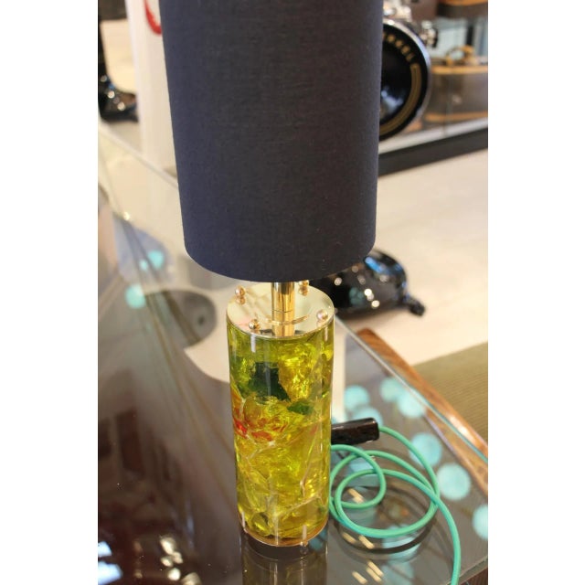 This cylindrical lamp features a color range from yellow to green with dark green and red inclusions. Up to 250V...