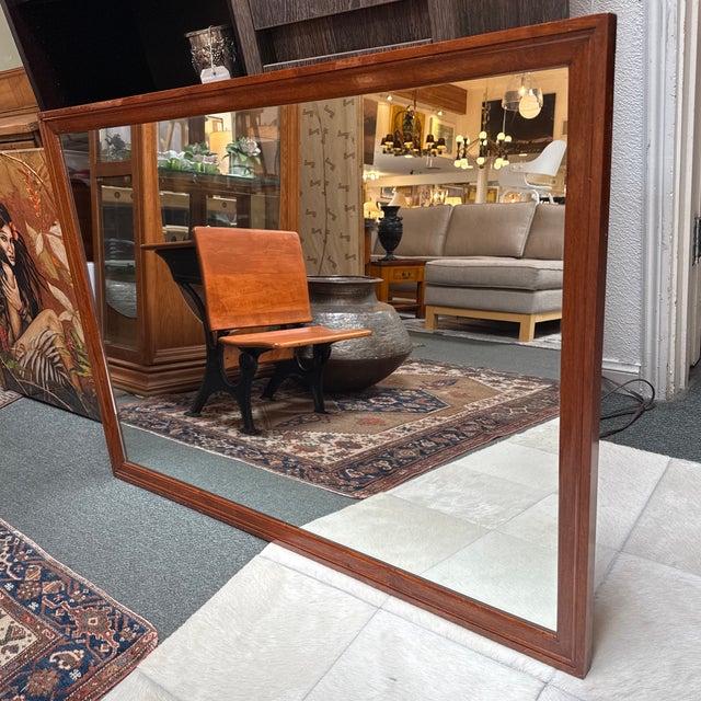 Design Plus Gallery presents a Vintage Rosewood Framed Wall Mirror. The rectangular mirror is bordered by a solid rosewood...