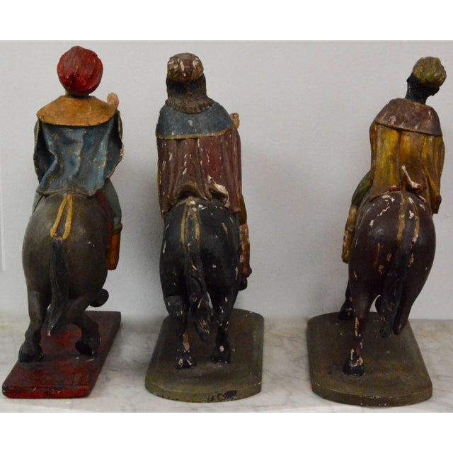These figures depict the three wise men on horseback. Each figure has polychrome paint decoration on carved wood and glass...