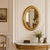 Antique Italian oval wall mirror from the 19th century, crafted in wood with a gilt gold-leaf finish. The frame features...