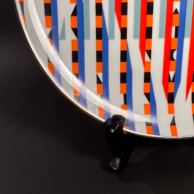 This plate is a collectible piece designed by Yaacov Agam, a renowned Israeli artist known for his contributions to...