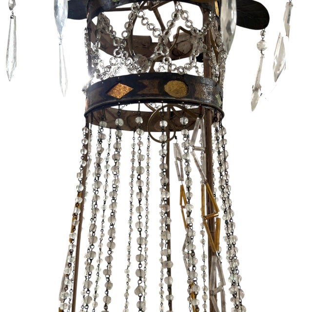 A striking 18th century Tuscan Empire chandelier featuring an elegant iron frame with a beautifully aged patina and...