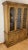 A mid-century Drexel china cabinet in a warm honey-brown wood finish. The upper hutch has three glazed doors with arched...