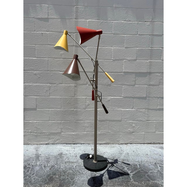A sculptural multi-arm floor lamp featuring articulating cone shades, balanced metal arms, and playful color blocking...