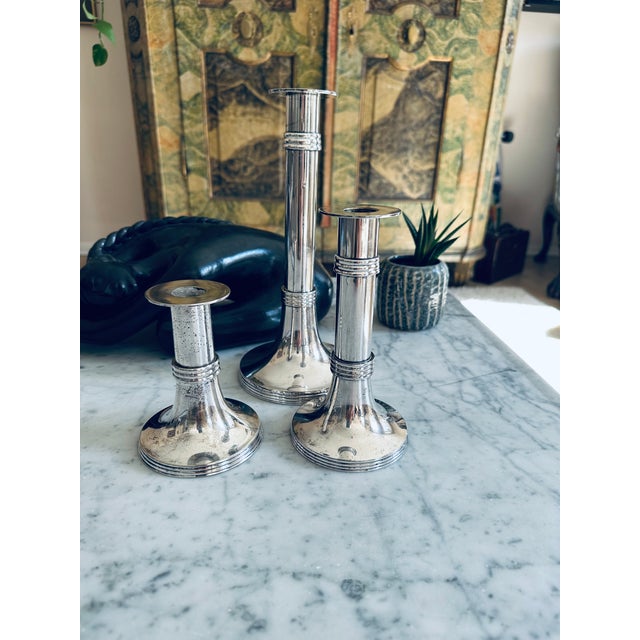 This elegant trio of silver-plated candlesticks was produced by the esteemed German design house Lambert in the 1960s....