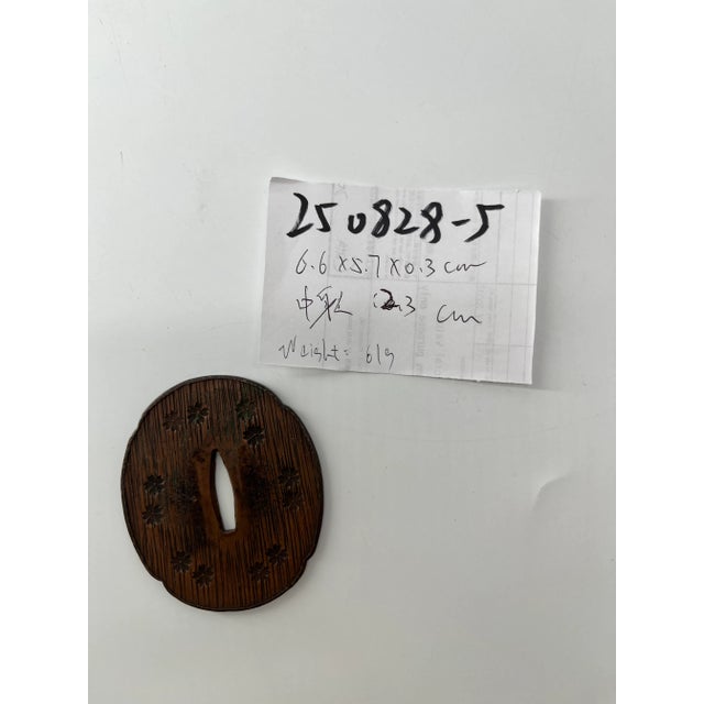 An authentic antique Japanese samurai sword hilt (tsuka) crafted from iron and beautifully engraved with traditional...