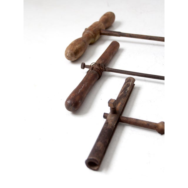 This is a collection of three early 20th century antique primitive hand beam augers. They feature wood t-bar handles with...